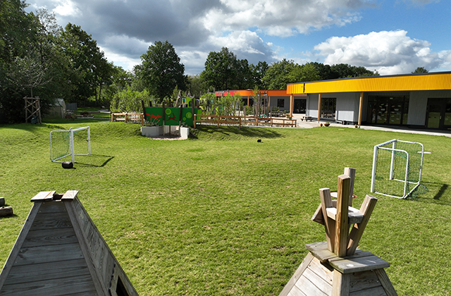 Zwei Tipi-Spitzen vor Garten und Haus-Rückseite